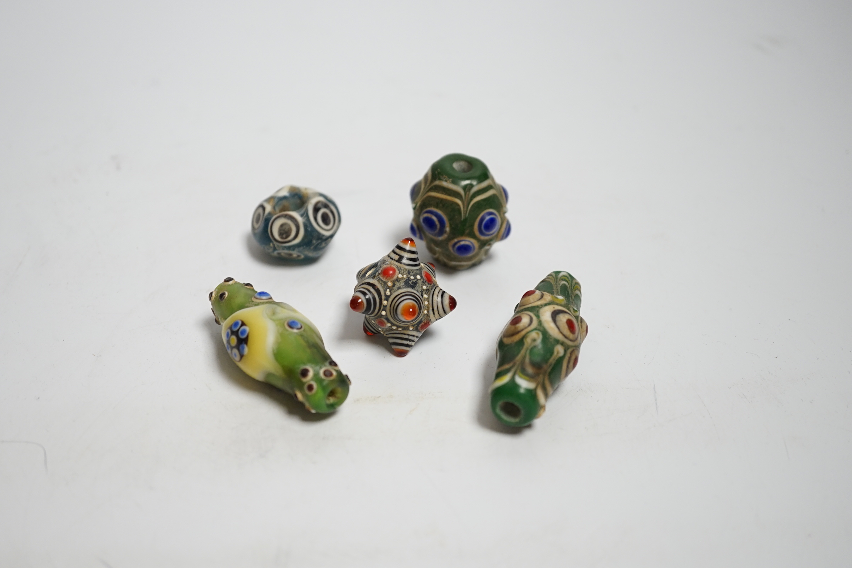 Five Eastern glass beads, largest 5.5cm long